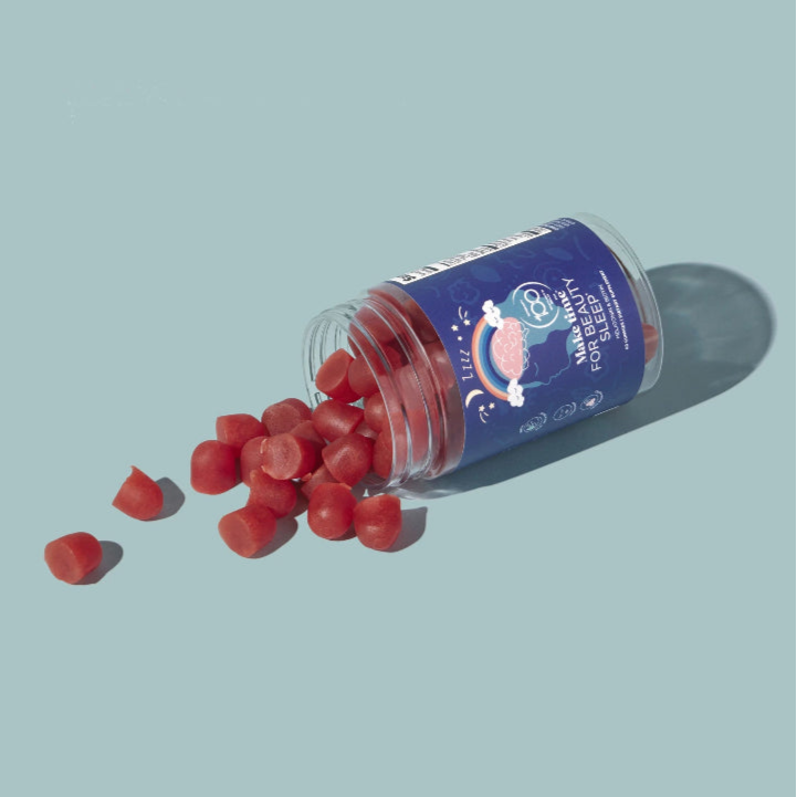 Open container of Make Time for Beauty Sleep gummies with a blue label on a light blue background