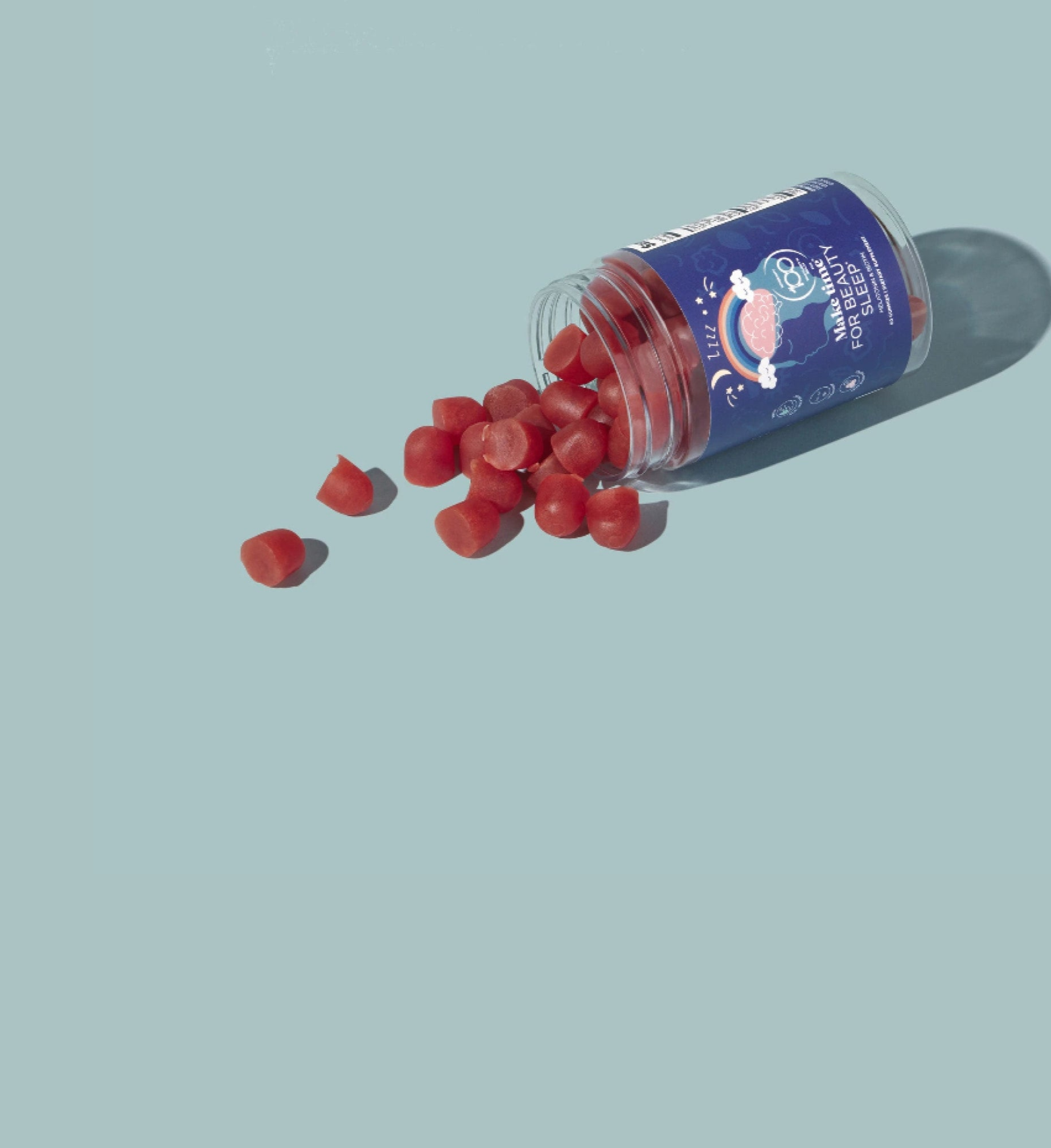 Open container of red gummies on a light blue background make time for beauty sleep