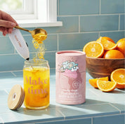 Make Time Brain, Body & Beauty powder scooped into a glass of water with oranges