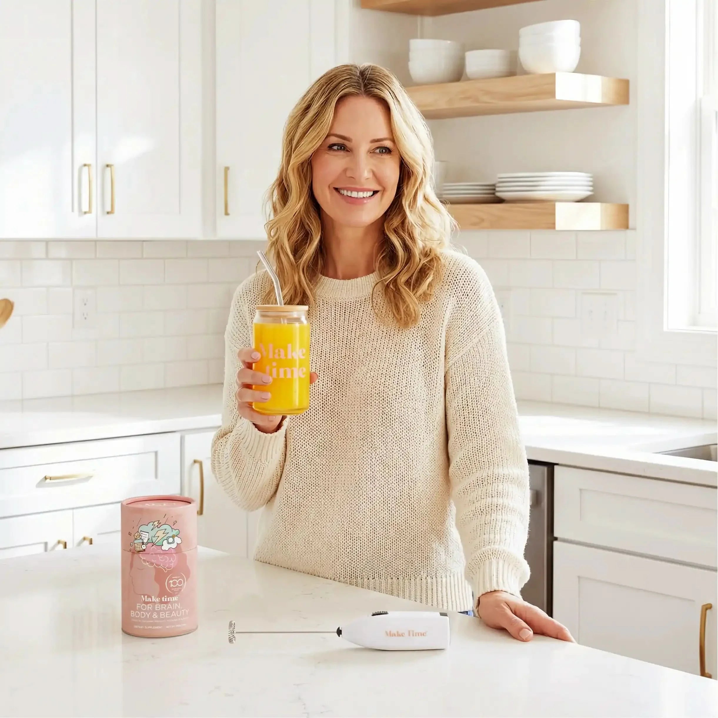 Woman smiling with a glass of Make Time Brain, Body & Beauty powder