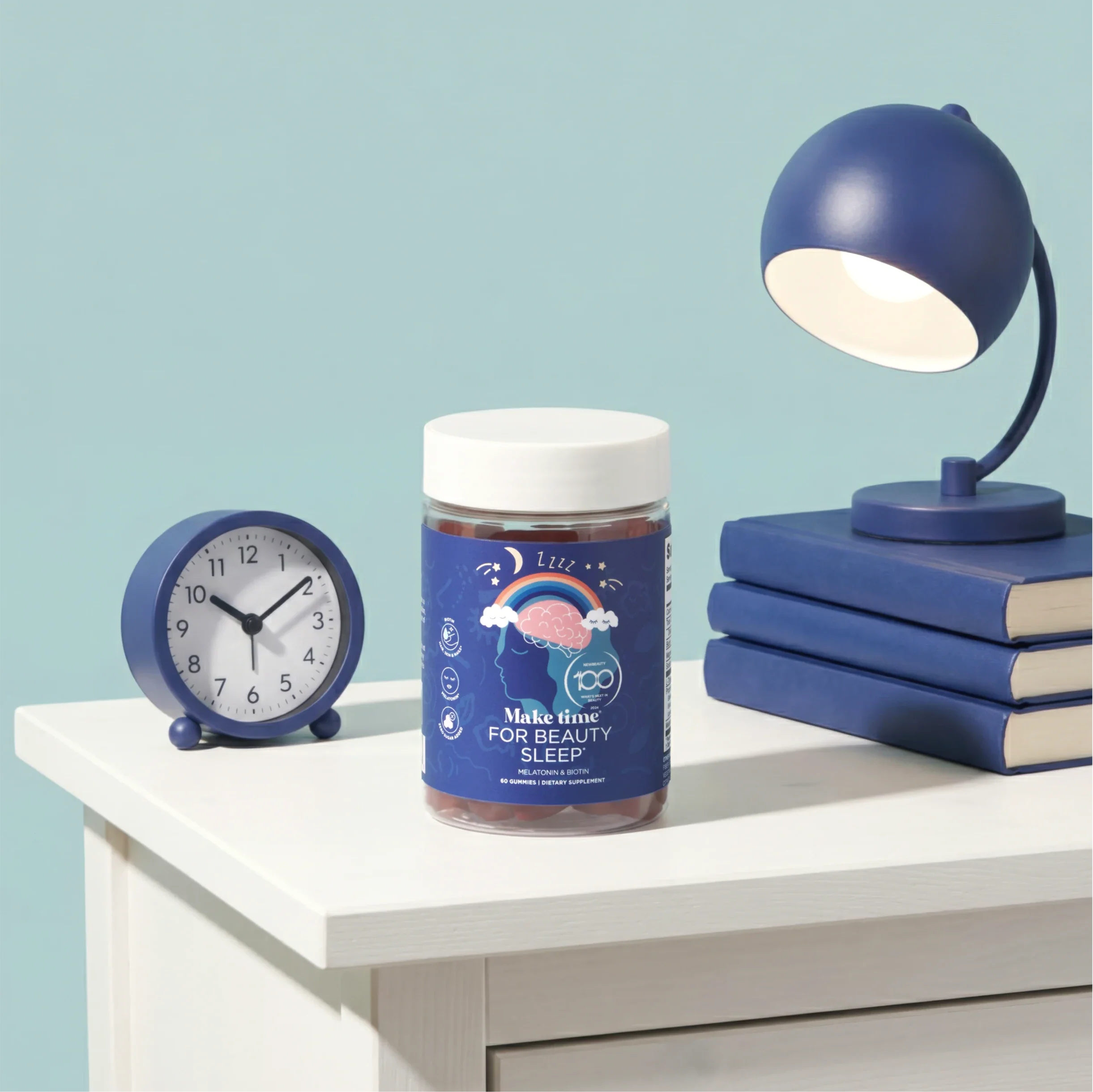 Make Time Beauty Sleep Gummy jar on a nightstand with a lamp and alarm clock