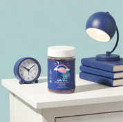 Make Time Beauty Sleep Gummy jar on a nightstand with a lamp and alarm clock