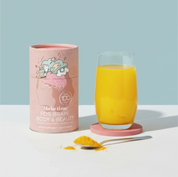 Orange drink made with Make Time Brain, Body & Beauty powder next to the canister
